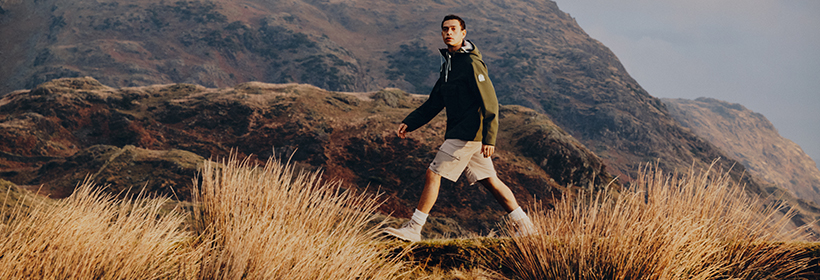 Mann mit Shorts und Jacke, Landschaft, Berge, Frühlingskleidung